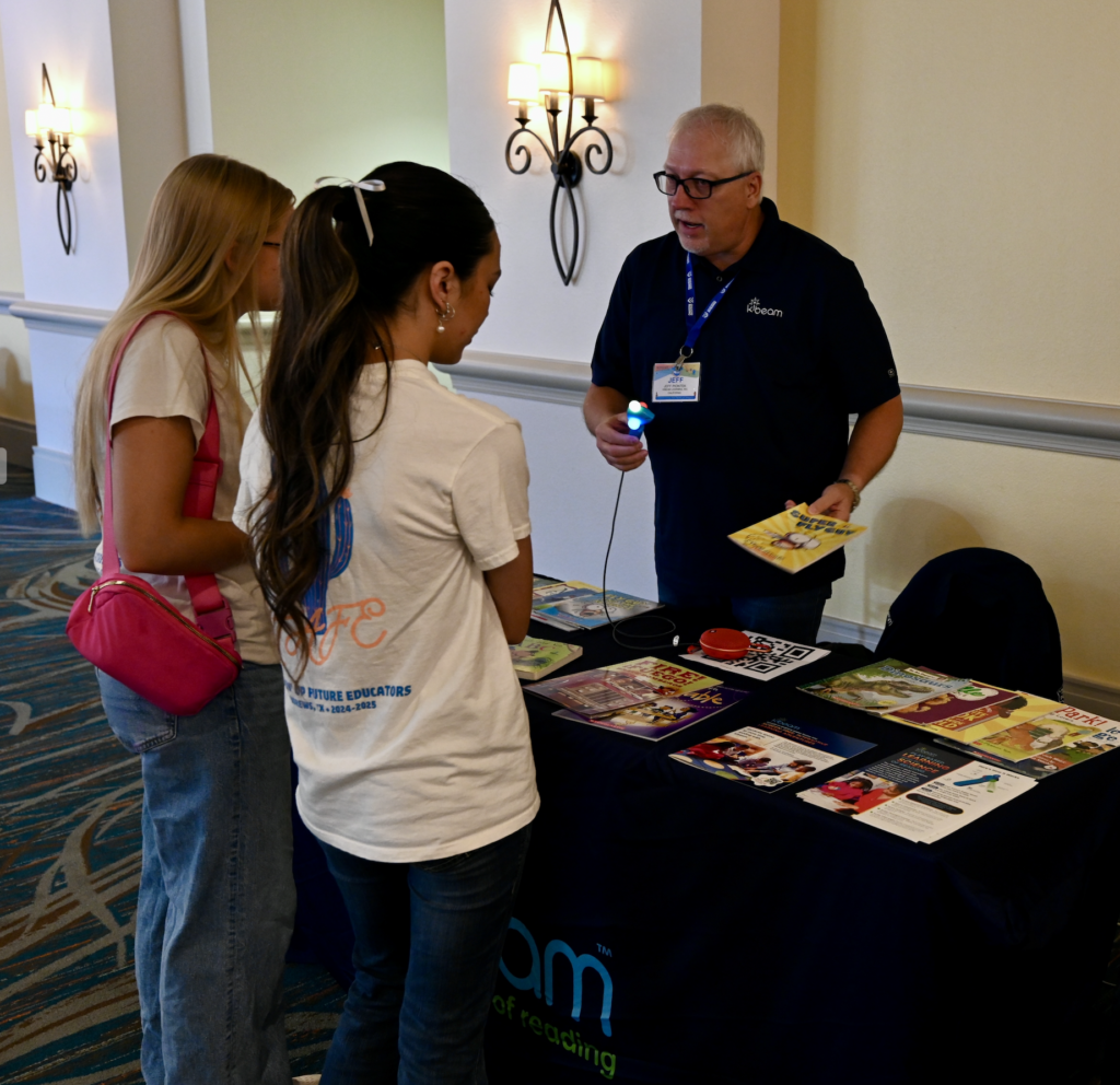 Students chatting with a conference exhibitor