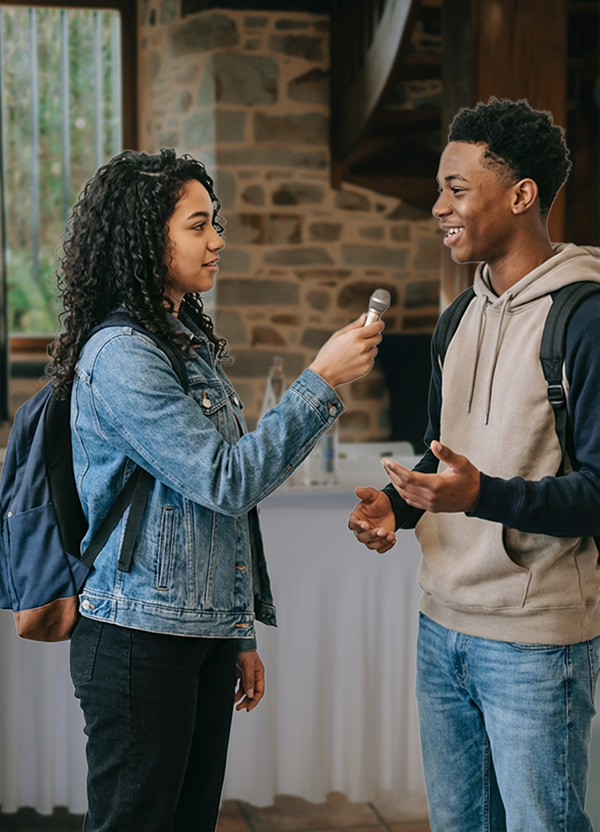 Student interviewing conference attendee